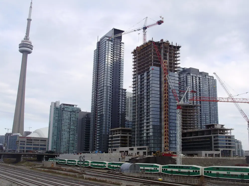 CityPlace condo towers, some still under construction, beside the rail corridor, with the CN Tower behind, Toronto