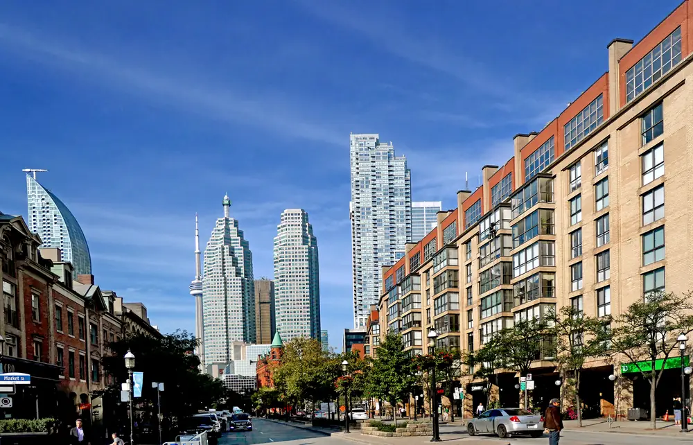 Front Street East in downtown Toronto, with brick mid-rise apartments and the towers of the Financial District behind