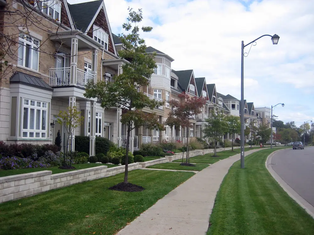 A row of townhouses with bay windows along a curving sidewalk in St. Lawrence Park, Port Credit, Mississauga
