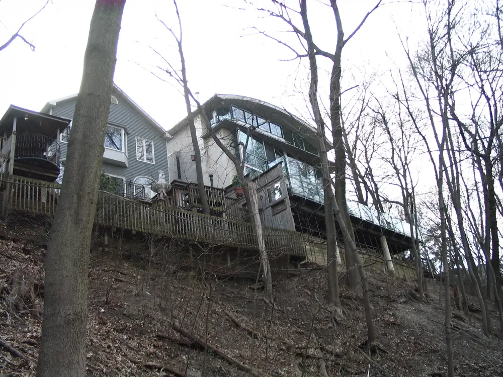 Houses seen through bare trees on a wooded slope on Summerhill Gardens, Summerhill, Toronto