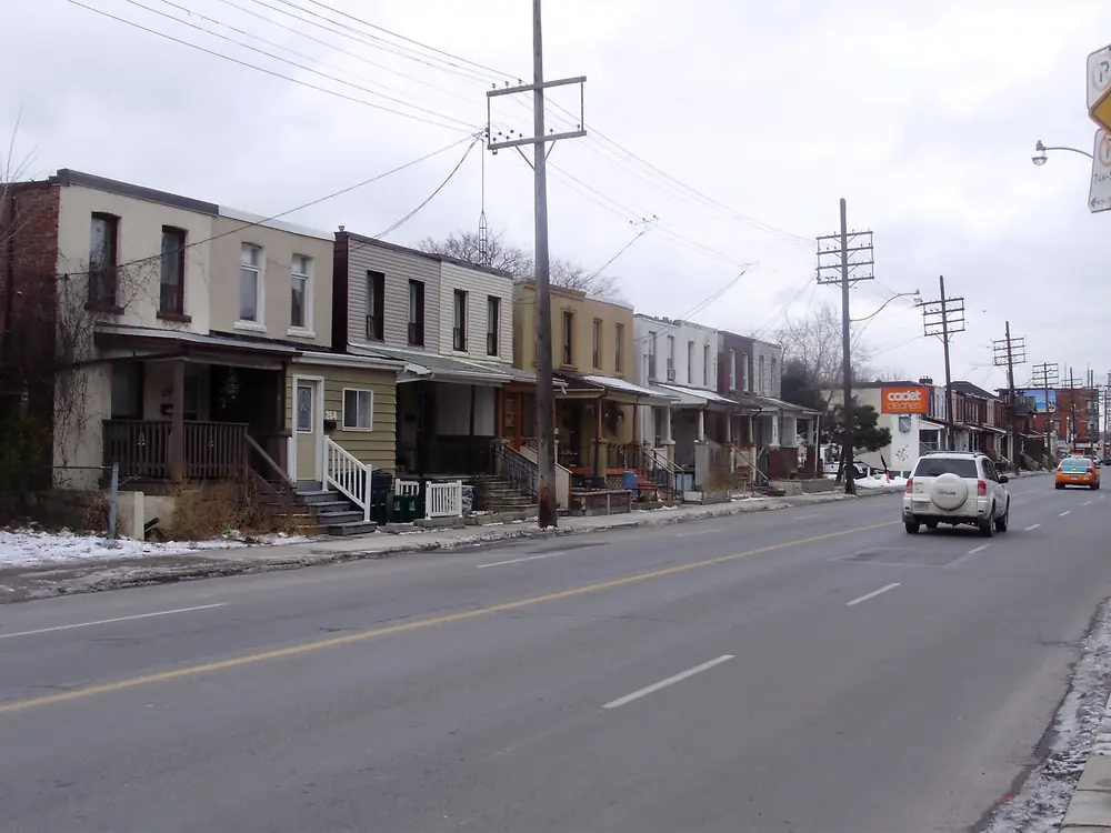 Rows of two-storey brick houses with front porches along Old Weston Road, York, Toronto