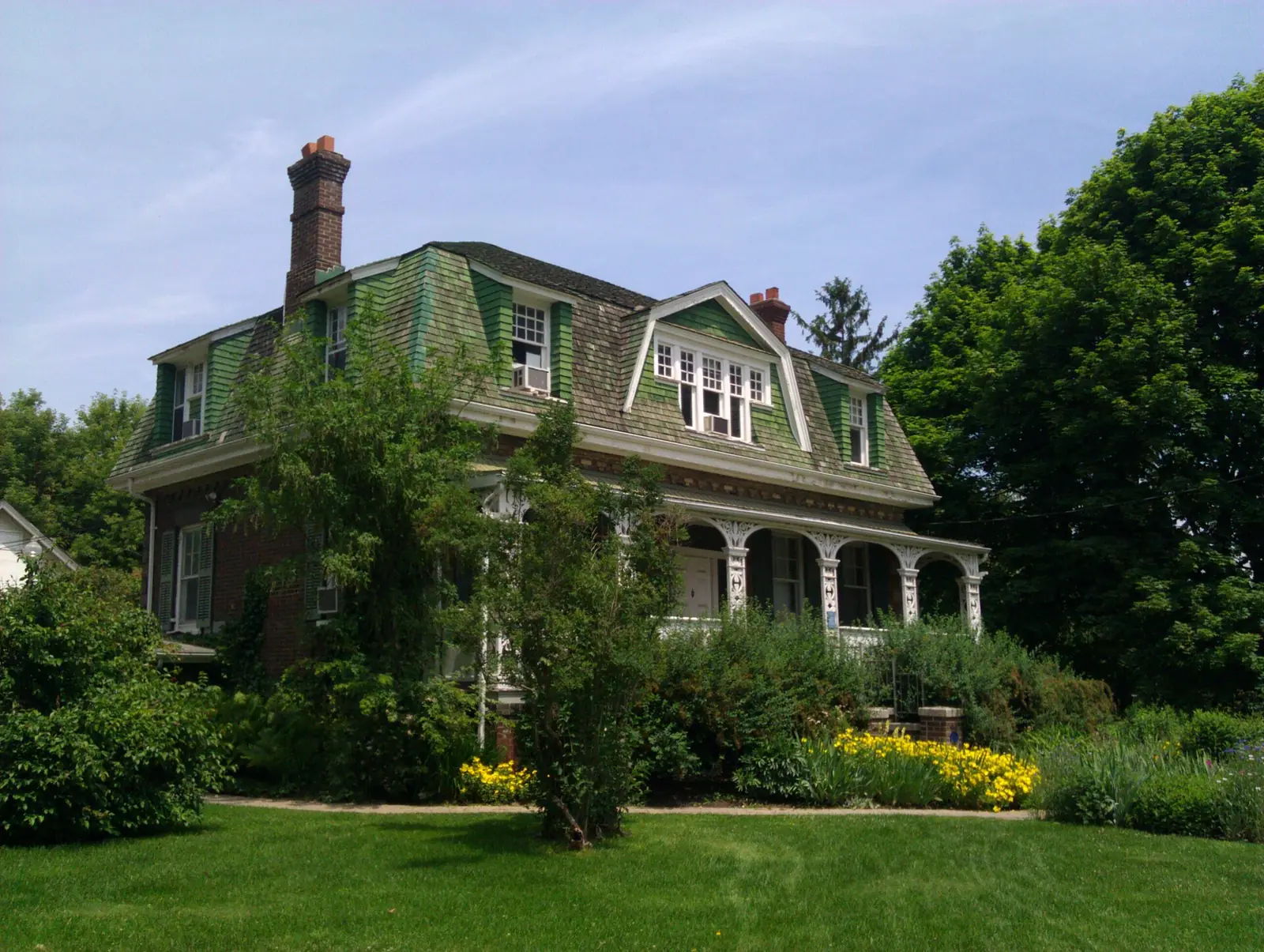 The historic Ashbridge Estate house behind summer gardens on Queen Street East, Leslieville, Toronto