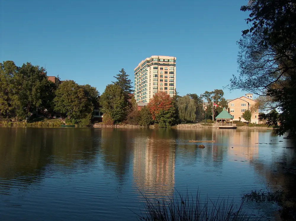 Apartment buildings and autumn trees reflected in the Mill Pond in Milton