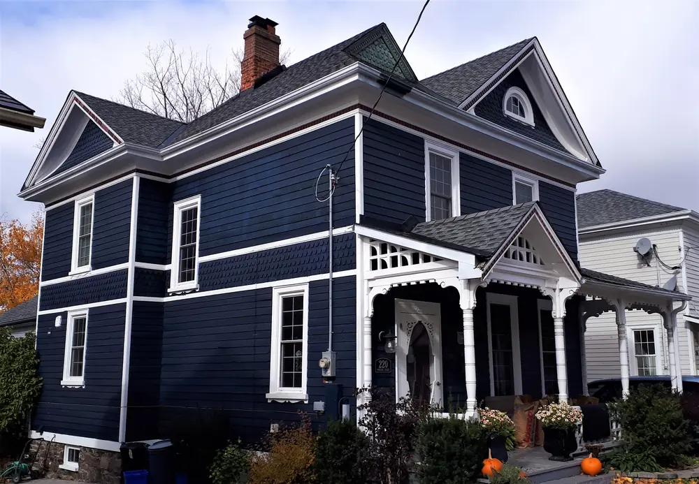 A navy-blue Victorian house with white trim and a front porch on Prospect Street in Newmarket