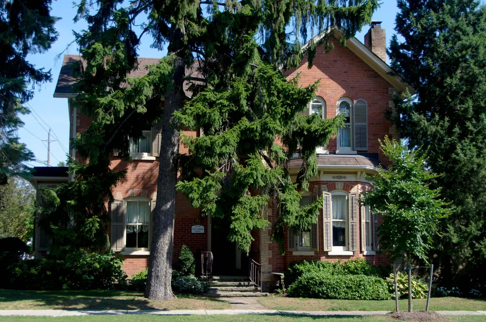 The Henry Gulledge House, a red-brick Victorian home among trees on Trafalgar Street, Oakville