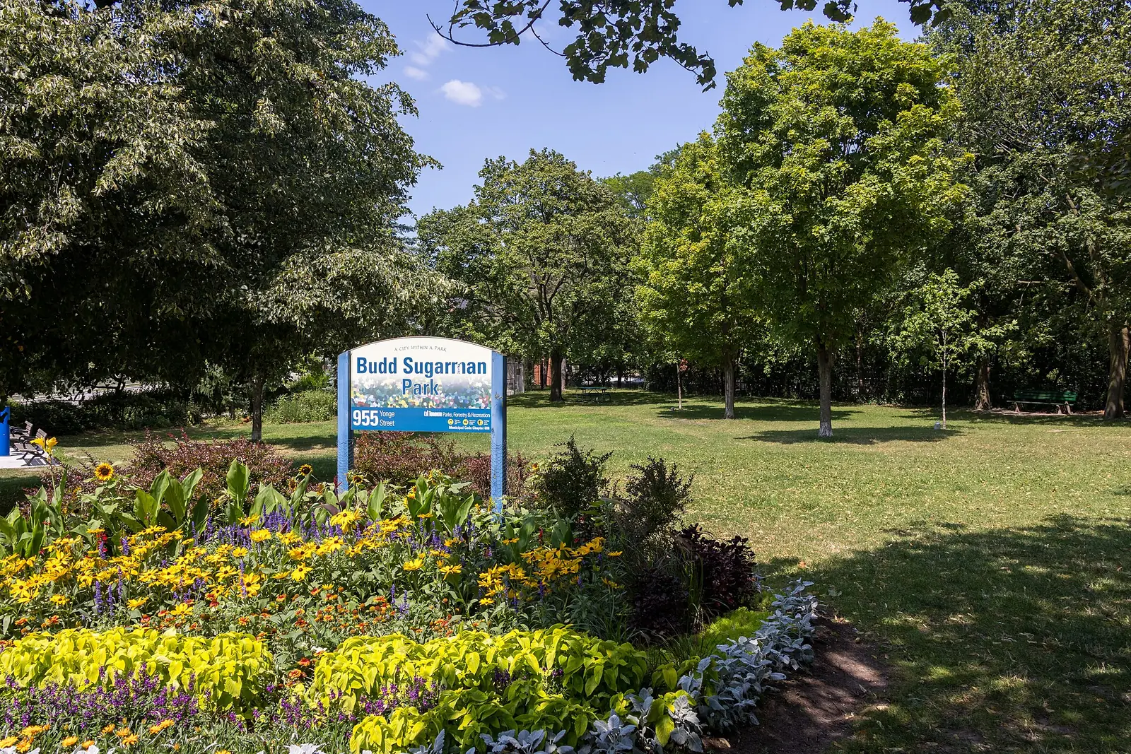 Summer flower beds and shade trees in Budd Sugarman Park at Yonge Street and Aylmer Avenue, Rosedale, Toronto