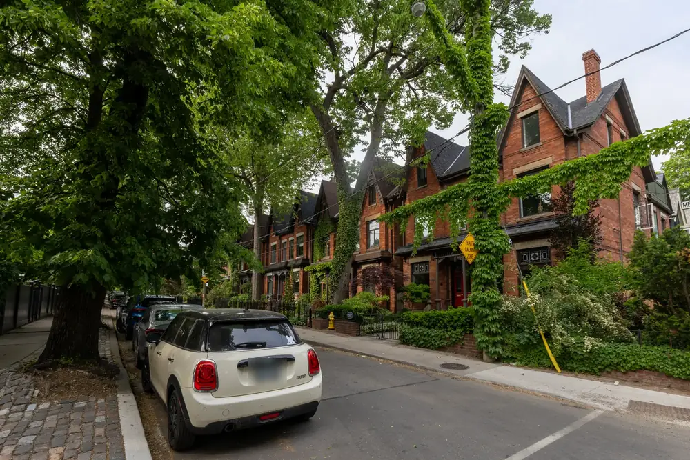 Victorian brick houses covered in ivy under large trees on Metcalfe Street, Cabbagetown, Toronto