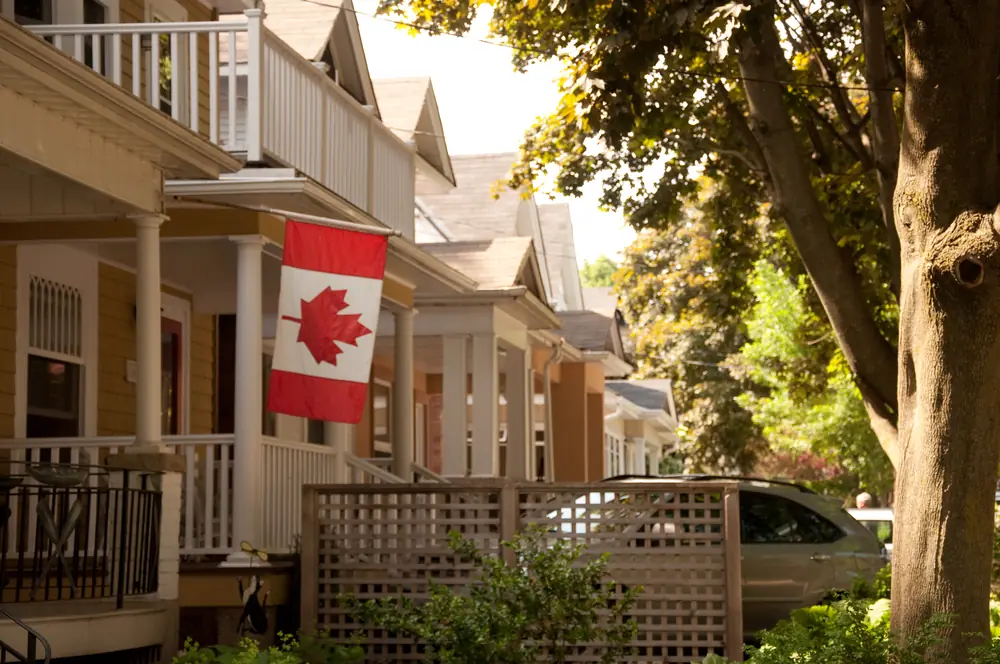 Wooden front porches with a Canadian flag on a row of houses in The Beaches, Toronto