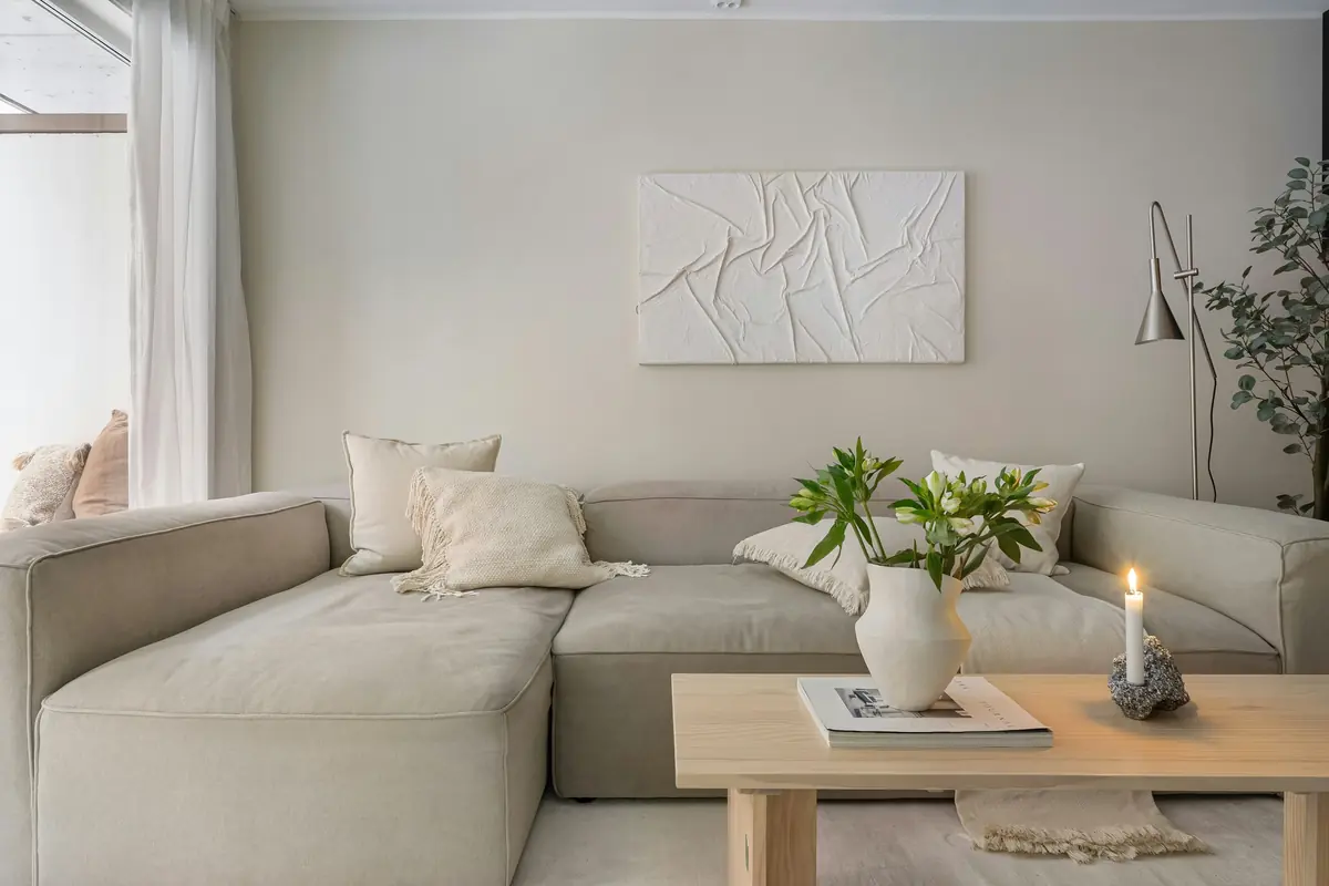 A calm, freshly cleaned living room with a linen sectional and oak coffee table
