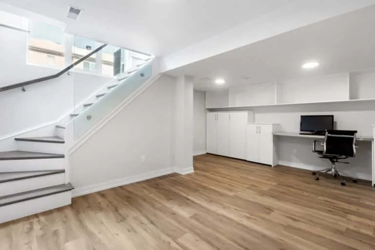 A clean finished basement with light wood floors