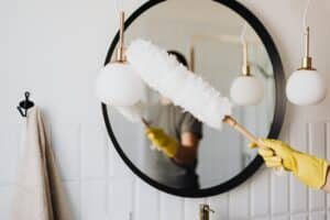 Cleaning a mirror with cleaning yellow gloves