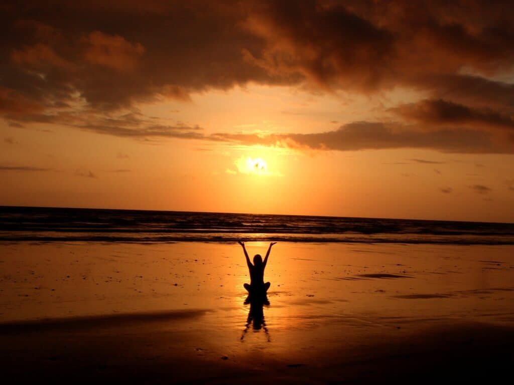 Person stretching at sunset outdoors