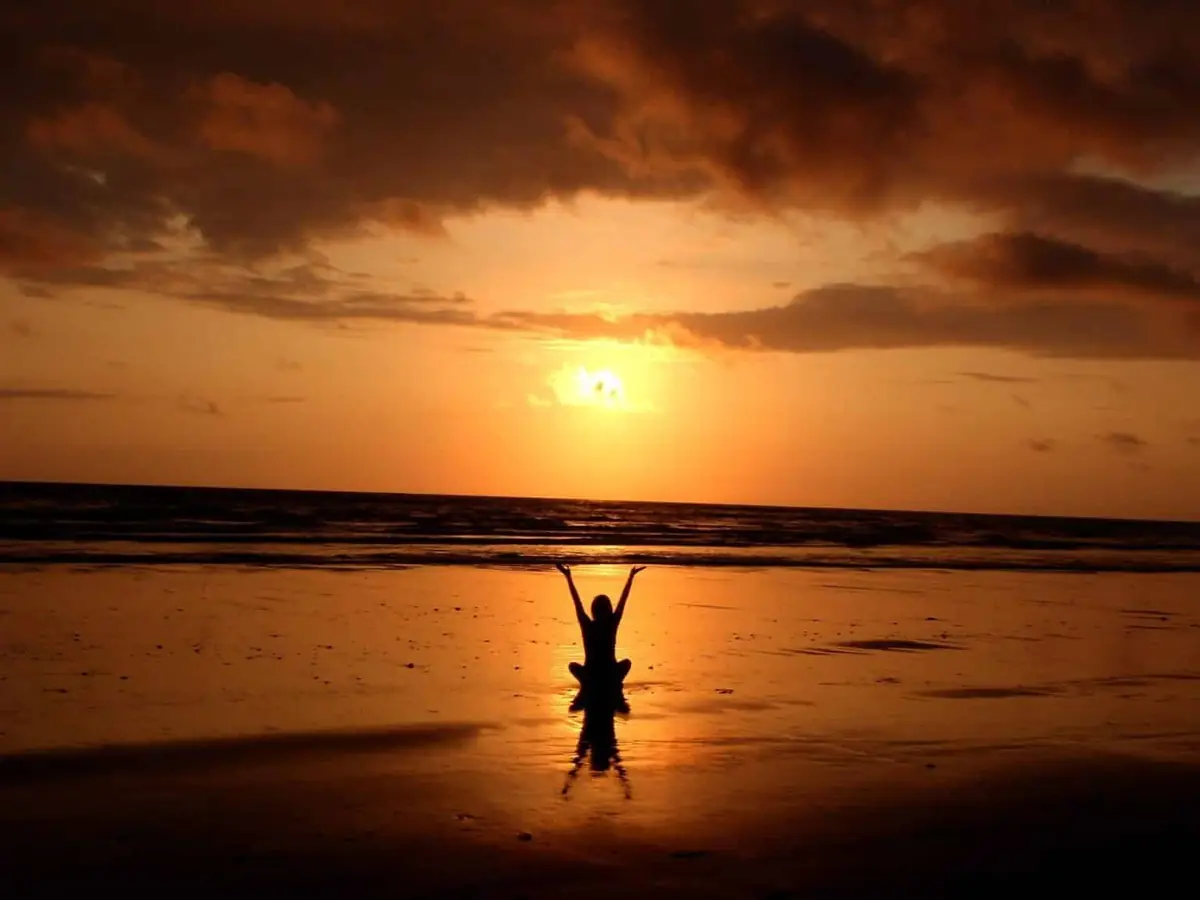 Person stretching at sunset outdoors
