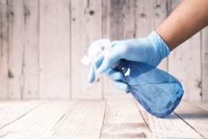 person holding atomizer with cleaning agent