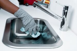 Woman cleaning a sink with gloves deep cleaning