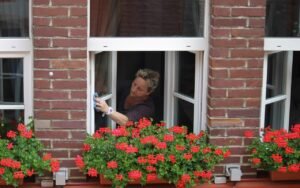Woman washing balcony windows at home.