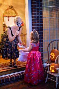 Trick or treat woman and child at home