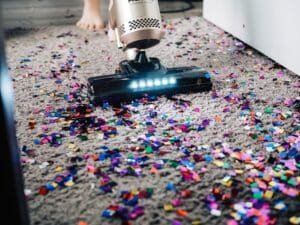 Cleaning confetti on the floor using a vacuum