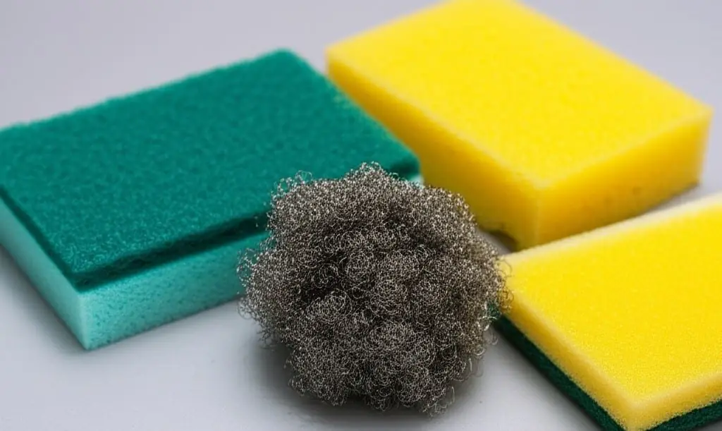 Green-backed and yellow scrub sponges beside a steel wool pad
