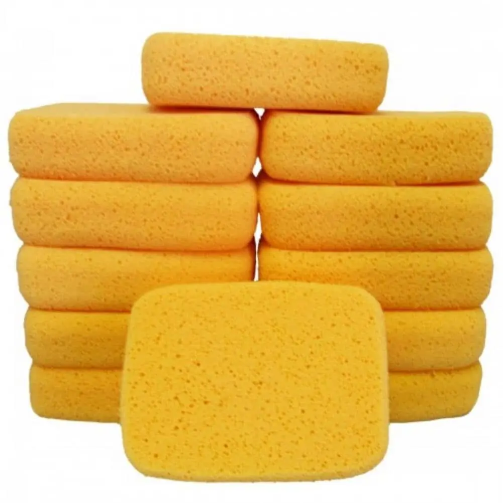 Stack of rounded yellow grout sponges on a white background