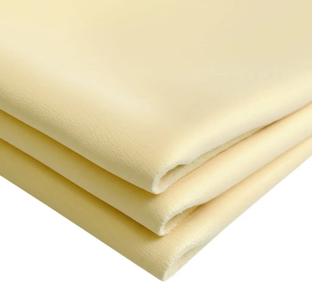 Folded pale yellow chamois cloths on a white background