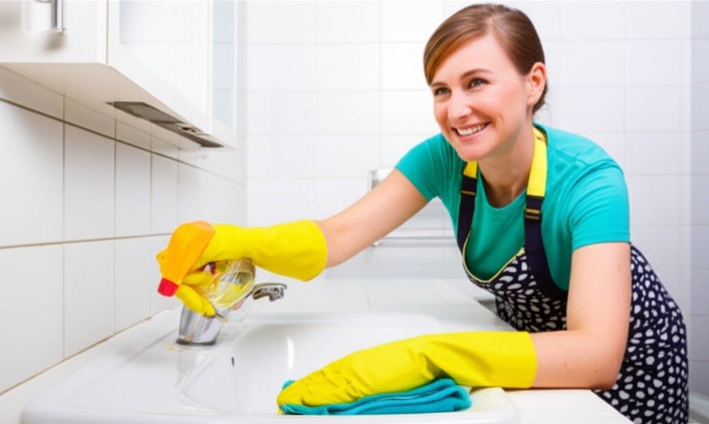 woman cleaning bathroom stove